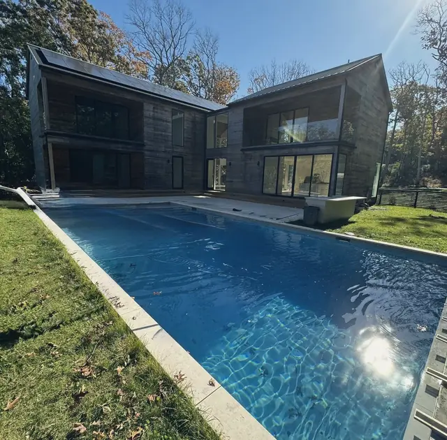 Pool beside a modern wood-clad house