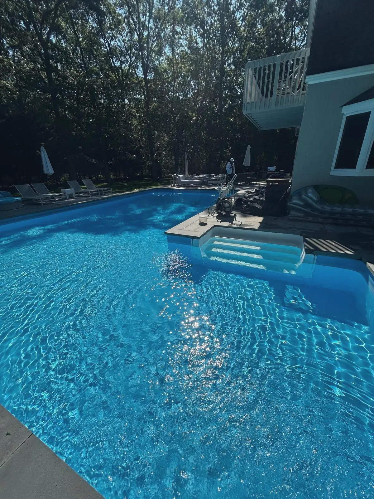 Sunlit pool with white entry steps